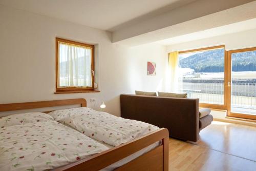 1 dormitorio con cama y ventana grande en Appartements Durnbrunn, en Valdaora
