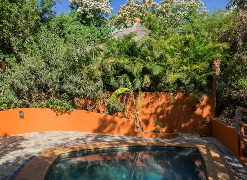a backyard pool with a fence and trees at Cabañas Amaia in Mazunte