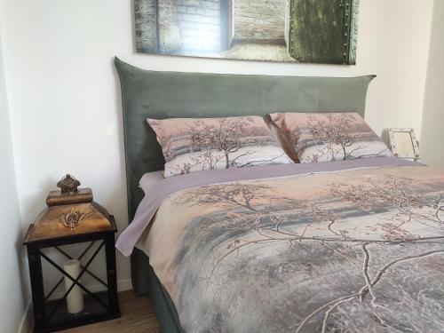 una camera da letto con letto con testiera verde e cuscini rosa di Best view Pula a Pola (Pula)