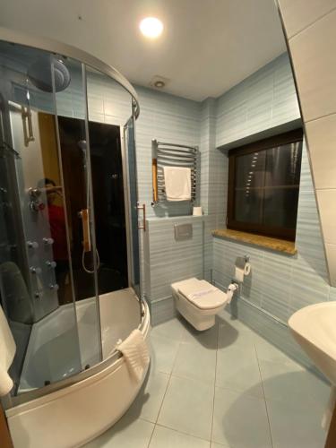 a bathroom with a shower and a toilet and a sink at Hotel City Park Barlinek in Barlinek