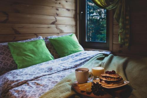 a table with two cups of coffee and a cake on a bed at Domek pod Klonem in Żary