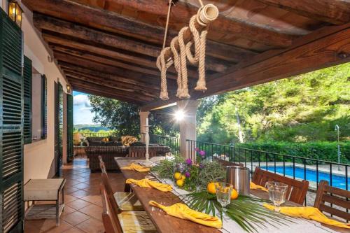 a dining table on a patio with a view of a pool at Finca Es Collet in Felanitx