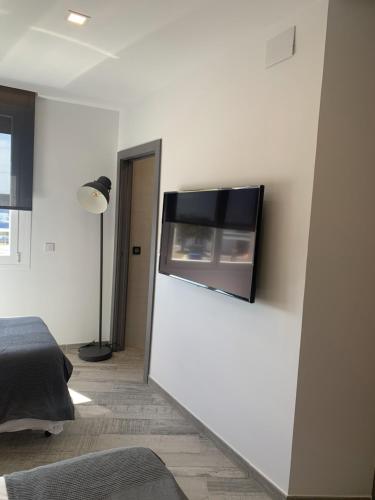 a room with a white wall with a television on it at Hotel Riojano in Humanes de Madrid