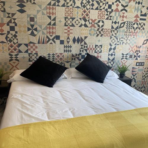 a bed with two pillows on it in a bedroom at Hotel Riojano in Humanes de Madrid
