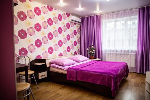 a bedroom with a purple bed and a purple wall at Diveevskiy Guest House in Diveevo