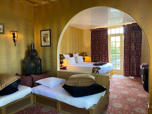 a bedroom with two beds with an archway in it at Domaine Saint Clair - Le Donjon in Étretat