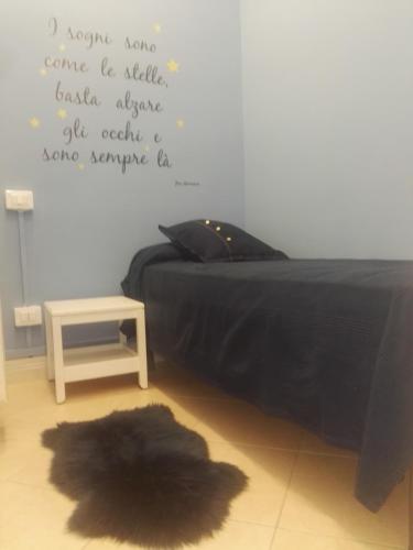 a bedroom with a bed with a black blanket and a rug at La terrazza di Maja in Chieti