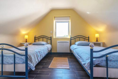 2 łóżka w pokoju z żółtymi ścianami w obiekcie Gîte Le Magourin w mieście Belz