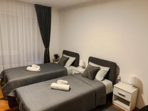 two beds in a bedroom with towels on them at Apartman Lana in Gospić