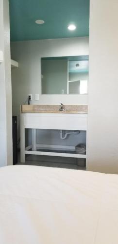 a bathroom with a sink and a mirror at Maxim III Motel in Houston