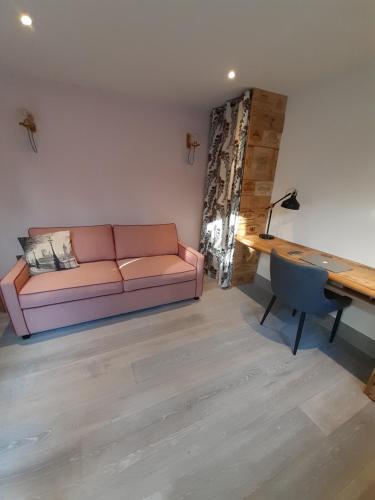 salon z kanapą i biurkiem w obiekcie Independent garden study w Londynie