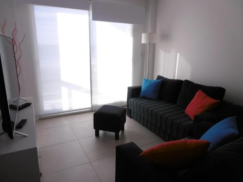 a living room with a couch and a chair at DEPTOS VIP en EDIFICIO FRENTE AL MAR-ZONA CONSTITUCION in Mar del Plata