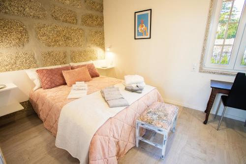 a bedroom with a bed and a chair in it at Fonte Velha in Castelões- Penafiel