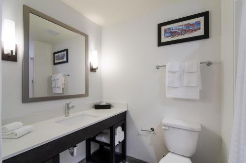a bathroom with a sink and a toilet and a mirror at Comfort Inn & Suites Gulf Shores East Beach near Gulf State Park in Gulf Shores