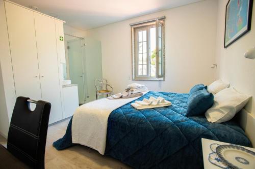 a bedroom with a blue bed with towels on it at Fonte Velha in Castelões- Penafiel