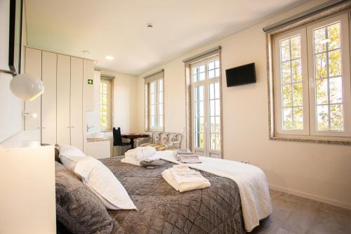 a bedroom with a bed with towels on it at Fonte Velha in Castelões- Penafiel
