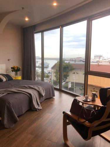 a bedroom with a bed and a large window at Apartments on Nesebrskaya 14 in Sochi