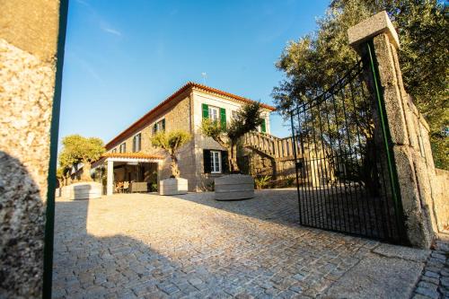 a gate to a house with a building at Fonte Velha in Castelões- Penafiel