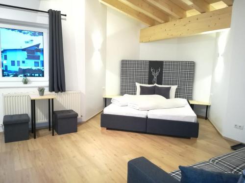 a bedroom with a bed and a large window at Apart Bergglück in Sankt Leonhard im Pitztal