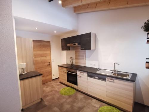 a kitchen with a sink and a stove at Apart Bergglück in Sankt Leonhard im Pitztal