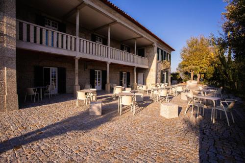 a patio with tables and chairs in front of a building at Fonte Velha in Castelões- Penafiel
