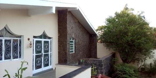 a white house with a door and a tree at Hostel e Pousada Solar in Poços de Caldas