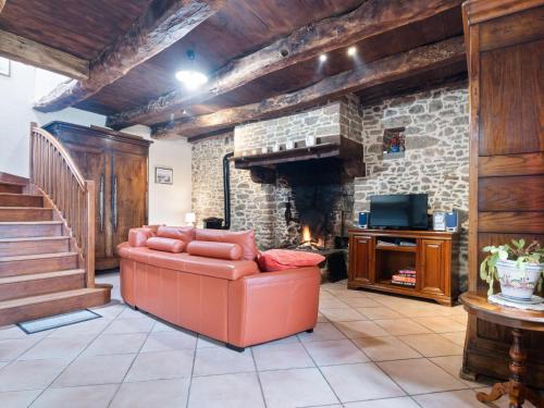 sala de estar con sofá y chimenea de piedra en Charming child friendly holiday home, en La Boussac