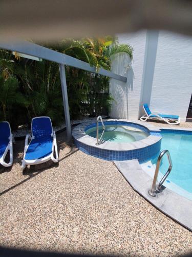 a swimming pool with two chairs and a hot tub at Mooloolaba Beach Beachwalk in Mooloolaba