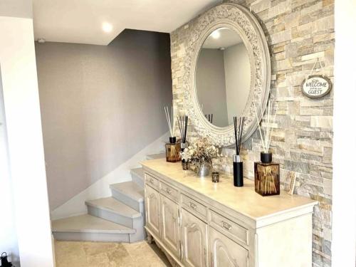 a bathroom with a dresser with a mirror and stairs at En toute simplicité in Lavilletertre