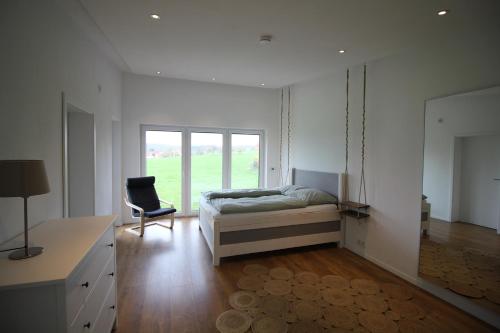 a bedroom with a bed and a desk and a chair at Modernes Ferienhaus im Schwarzwald in Freiamt