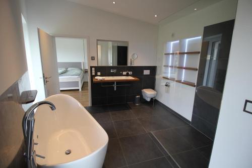 a bathroom with a sink and a bath tub at Modernes Ferienhaus im Schwarzwald in Freiamt