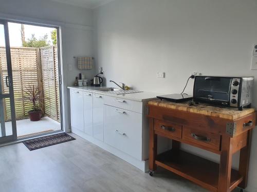 a kitchen with a microwave on top of a wooden table at Kerikeri Central Apartment in Kerikeri