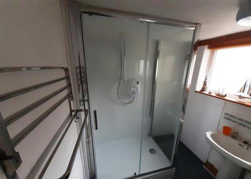 a glass shower in a bathroom with a sink at Plumtree Cottage in Cotgrave