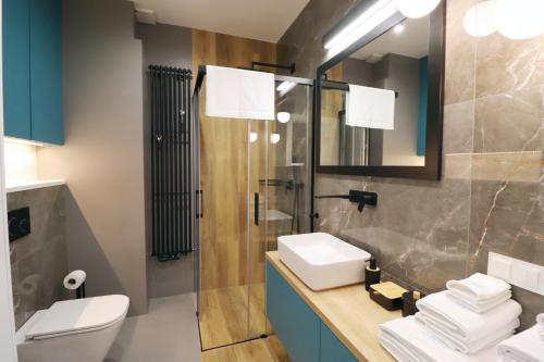 y baño con aseo, lavabo y ducha. en Apartament MARE - MTN Gardenia Seaside Dziwnów en Dziwnów