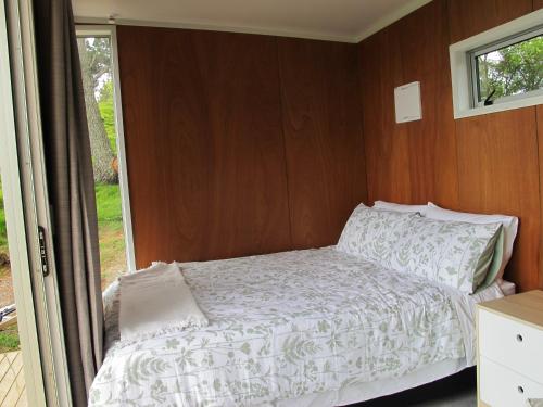 ein kleines Schlafzimmer mit einem Bett und einem Fenster in der Unterkunft Waihi Gold Alpacas 1 or 2 people in Waihi