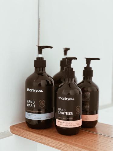 three bottles of hand wash sitting on a wooden shelf at The Loft - beautiful central Barossa apartment in Tanunda