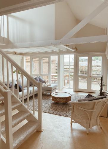a living room with a staircase and a couch at The Loft - beautiful central Barossa apartment in Tanunda
