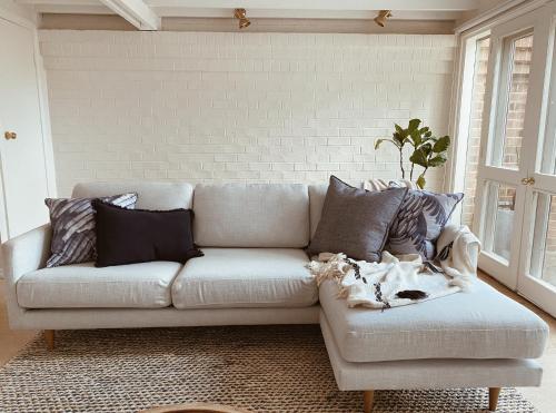 a living room with a white couch with pillows at The Loft - beautiful central Barossa apartment in Tanunda
