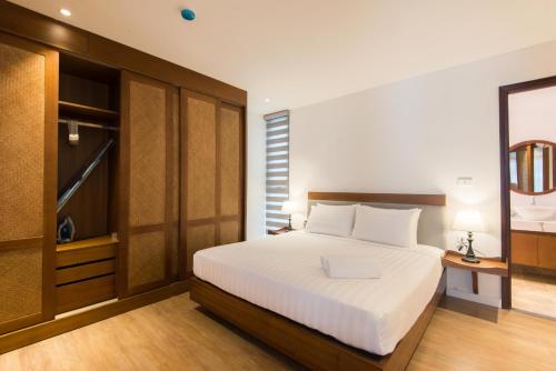 a bedroom with a large white bed and wooden cabinets at 22housing Hotel & Apartment 81 Linh Lang in Hanoi