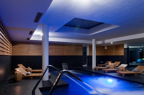 a hotel lobby with a swimming pool and chairs at Furadouro Boutique Hotel Beach & SPA in Ovar