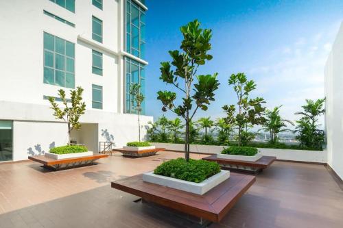 a courtyard with benches and trees in a building at Ellkay Studio Suite at Evo Bangi in Kampong Sungai Ramal Dalam