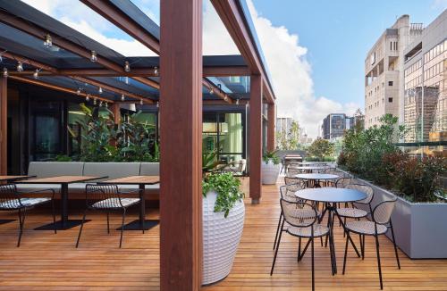 a restaurant with tables and chairs on a deck at Little National Hotel Sydney in Sydney