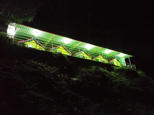 
a park bench with a lit up night sky behind it at Vertical Valley Resort in Chakrāta
