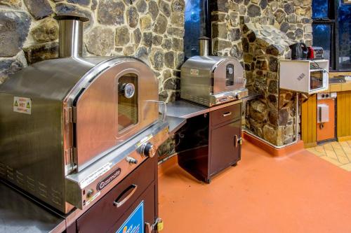 a kitchen with two ovens in a stone wall at Discovery Parks - Cradle Mountain in Cradle Mountain