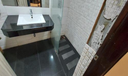a bathroom with a sink and a mirror at Broadway Inn in Jaipur