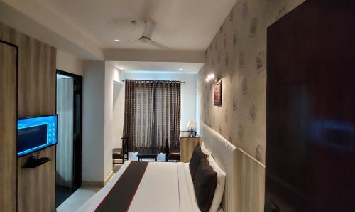 a hotel room with a bed and a television at Broadway Inn in Jaipur