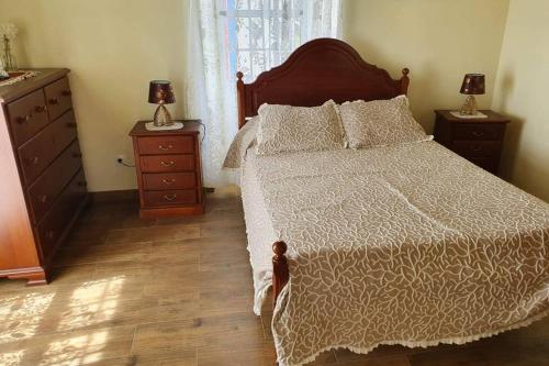 - une chambre avec un grand lit et 2 tables de chevet dans l'établissement casa Eira Alta, à Santa Bárbara