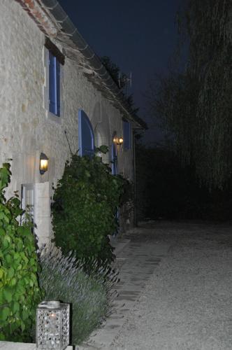 a building at night with lights on the side of it at Chambres d'Hôtes La Grange Au Bois in Champagne-et-Fontaine
