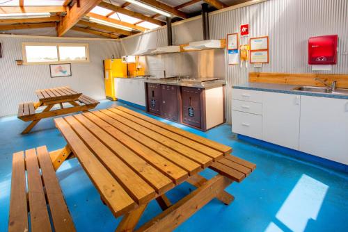 una gran cocina con bancos de madera y una mesa. en Discovery Parks - Devonport en Devonport