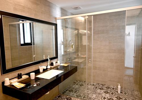 y baño con lavabo y ducha con espejo. en 澎旅品花灣民宿, en Magong